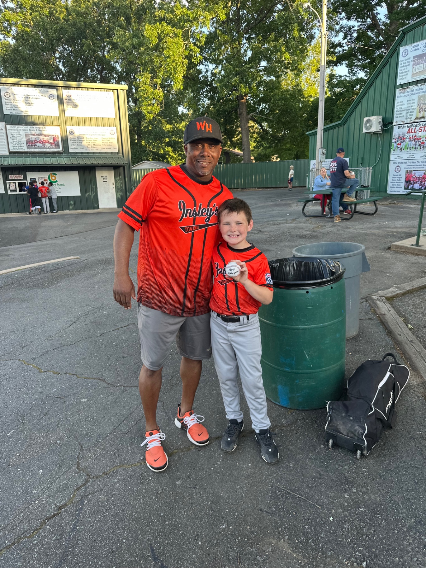 A coach with a young athlete holding an MVP ball near the concession stand